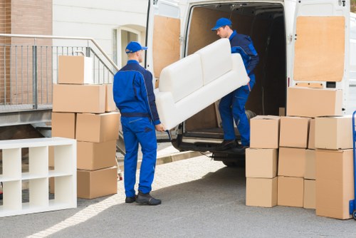 Removal van and movers handling household items at the start of a service