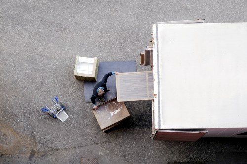 Careful handling of a piano through a narrow residential property staircase in North London